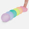 set of 6 mini memory gel stress balls in teal, yellow, pink, purple, misty blue, and peach lined up in a row and a model pressing the pink one