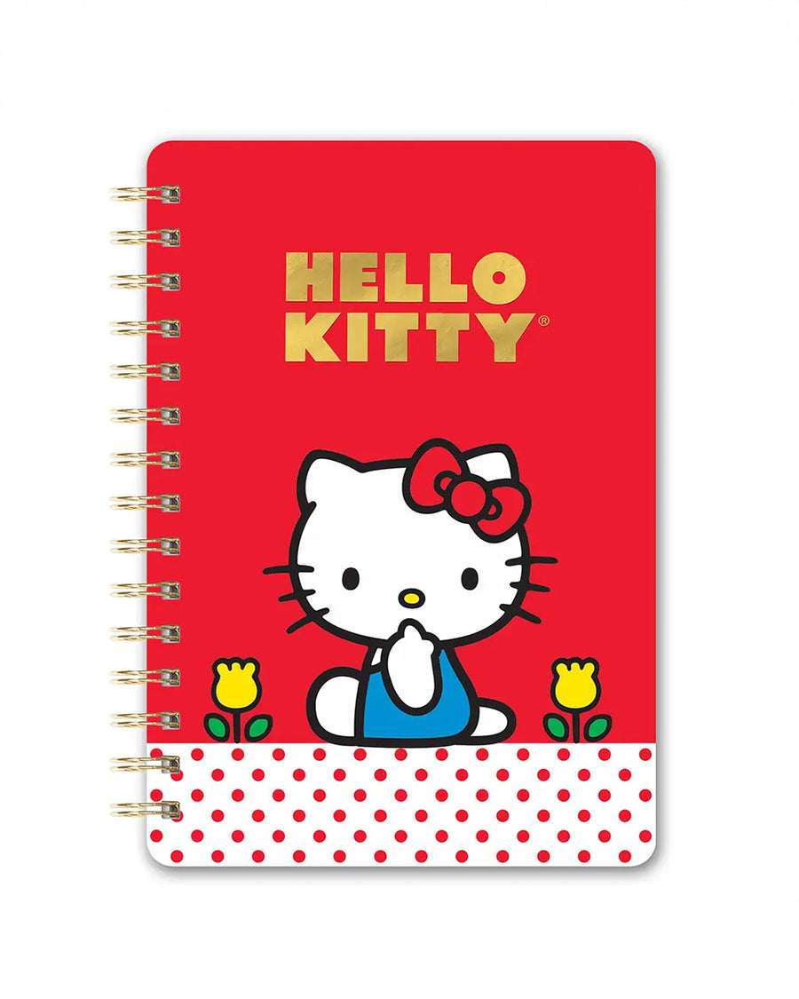 red notebook with gold foil 'hello kitty' and hello kitty character sitting on a white and red polka dot banner