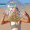 model holding gold, mint, and lavender confetti inflatable beach ball