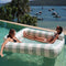 models floating in oversized mint and white stripe float for two people