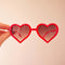 model holding red heart shaped sunglasses