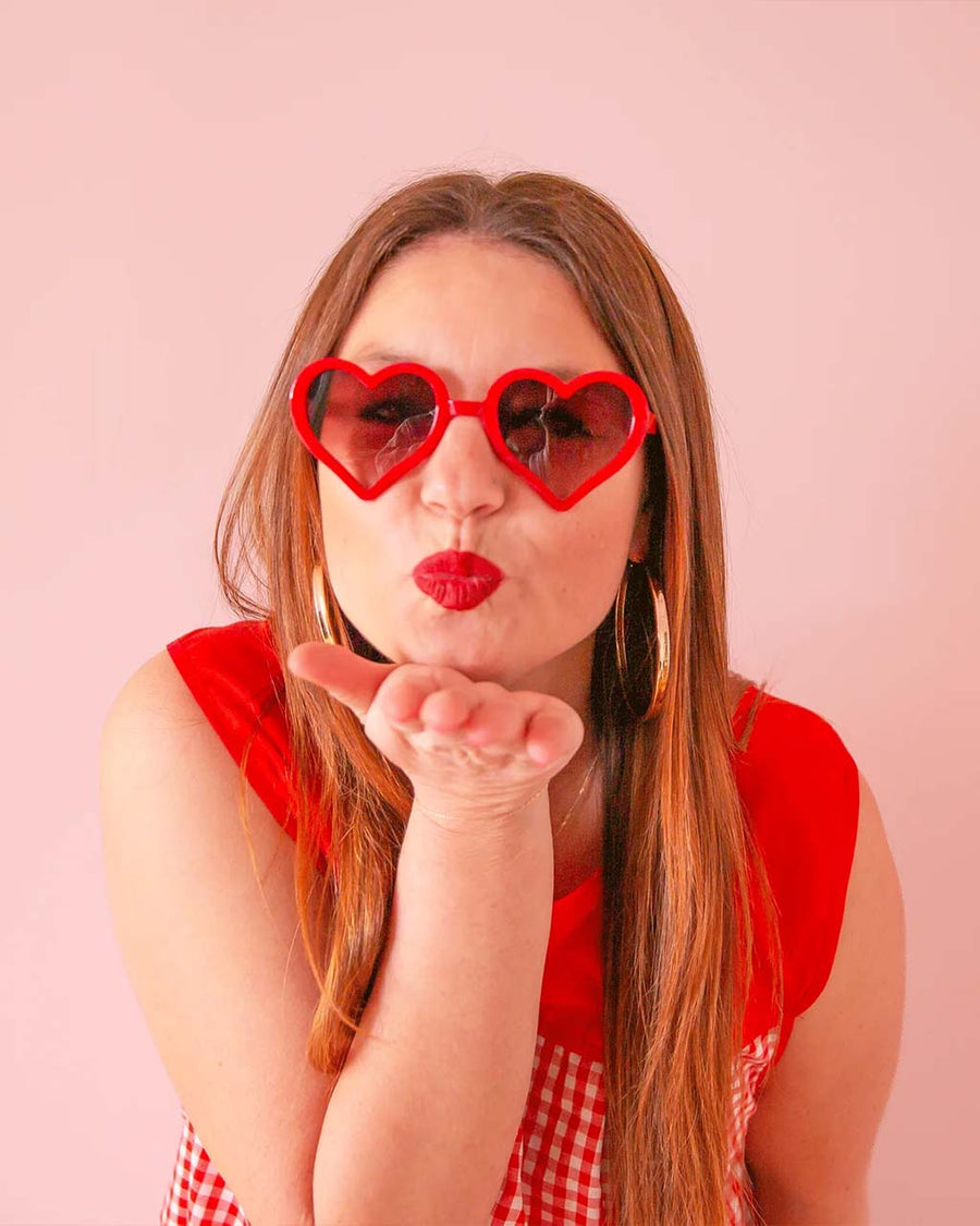 model wearing red heart shaped sunglasses
