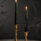 set of two black taper candles that drip green wax when lit