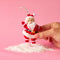 model holding red fuzzy retro dancing santa ornament