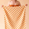 model holding orange and white checkered towel