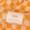 packaged orange and white checkered towel