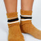 model wearing scrunched brown teddy socks with black and white stripes on the top