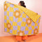 model holding lime and purple trippy checker with bold flower puffy blanket