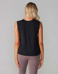 back view of model wearing black active tank with hi-lo hem and muscle tank sleeves