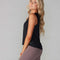 side view of model wearing black active tank with hi-lo hem and muscle tank sleeves