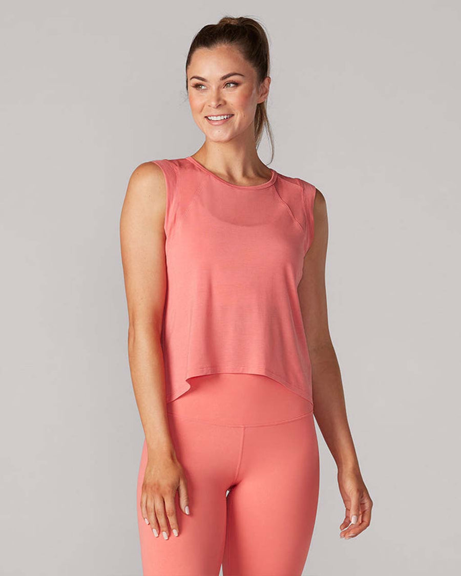 model wearing poppy pink active tank with hi-lo hem and muscle tank sleeves