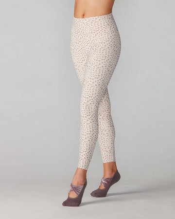 model wearing white high waisted active leggings with brown spotted print