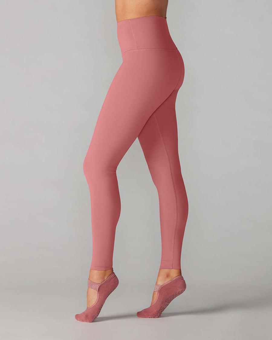 side view of model wearing high waist leggings in a dark mauve color