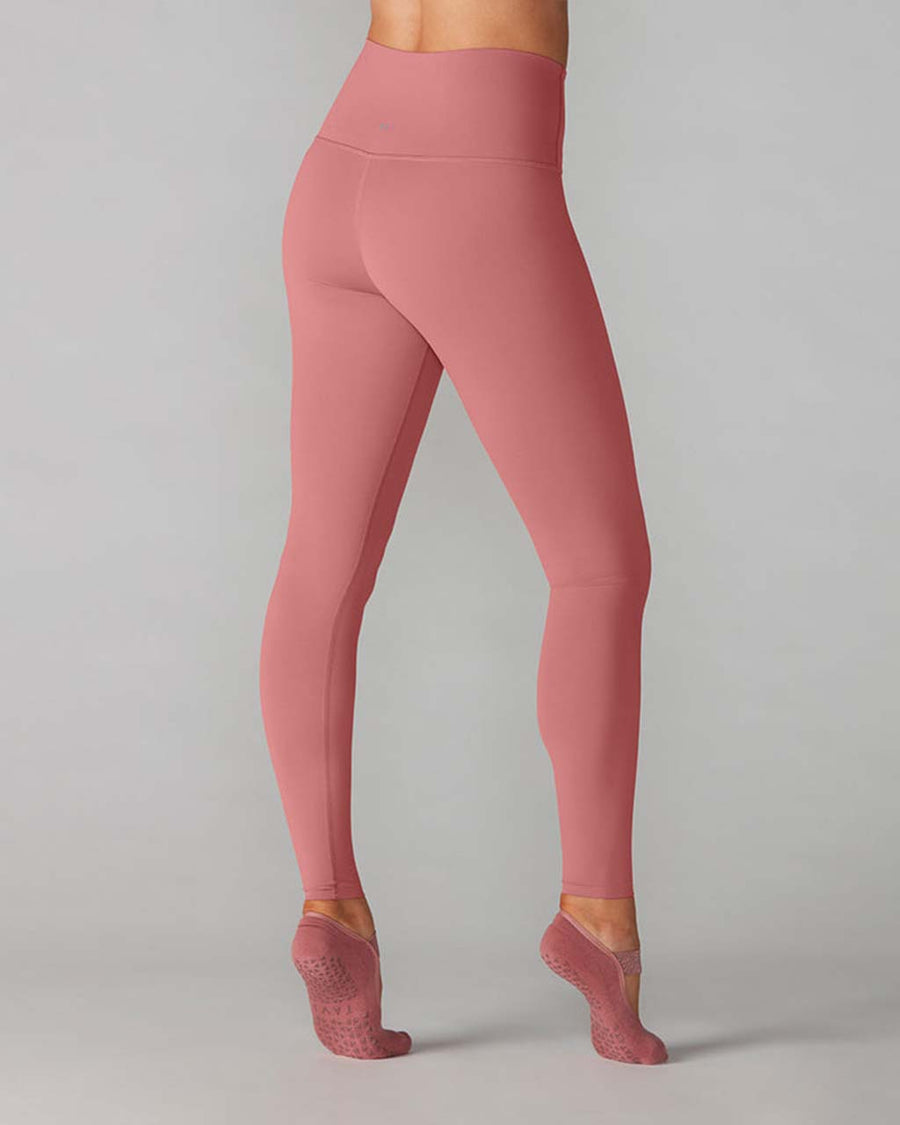 back view of model wearing high waist leggings in a dark mauve color