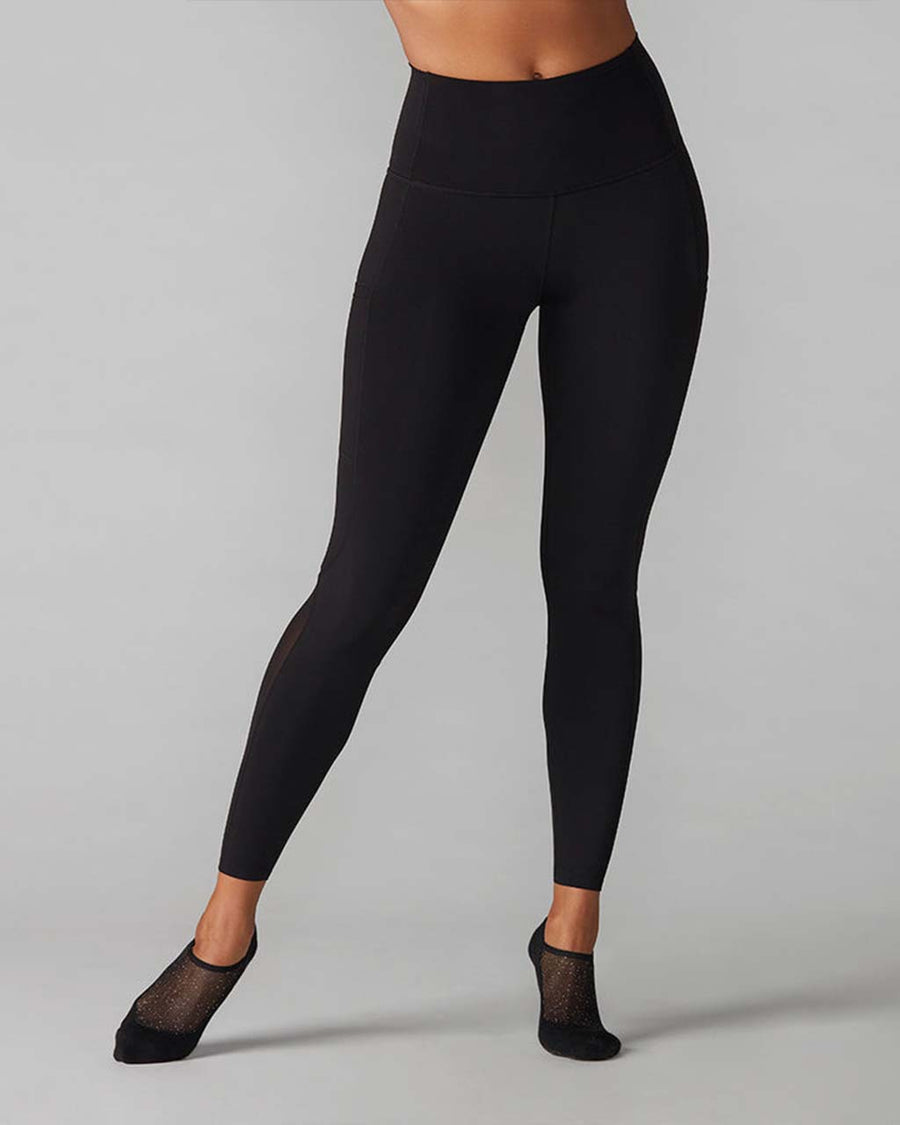 model wearing black leggings with mesh legs and side pockets