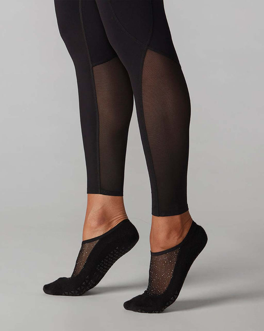 up close of model wearing black leggings with mesh legs and side pockets