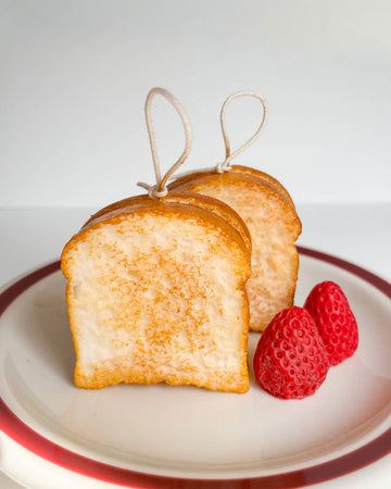 two realistic toast candles with strawberry candles next to them
