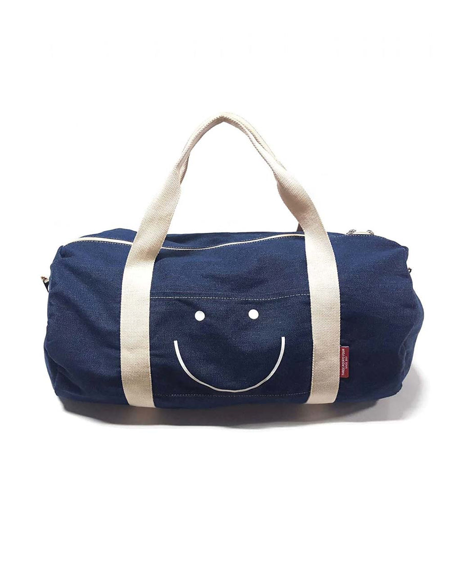 denim duffle bag with white smiley face and white straps