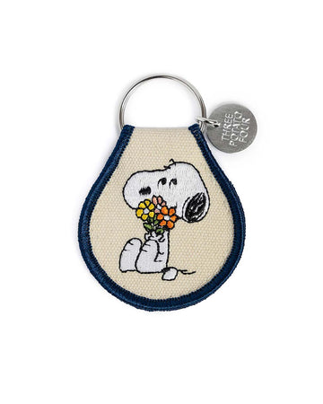 tan patch keychain with snoopy holding a bouquet of flowers and navy blue trim