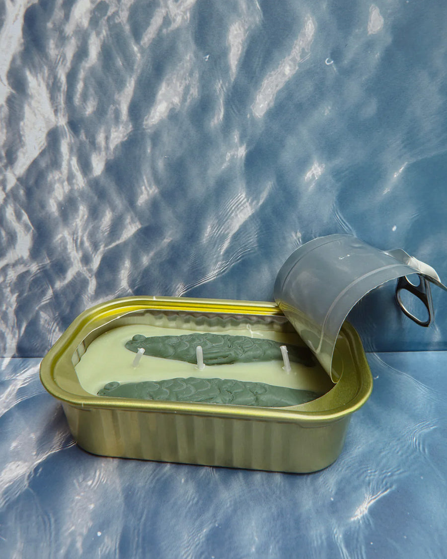 side view of opened green tea and lemongrass scented candle in a fish tin with fish candle inside