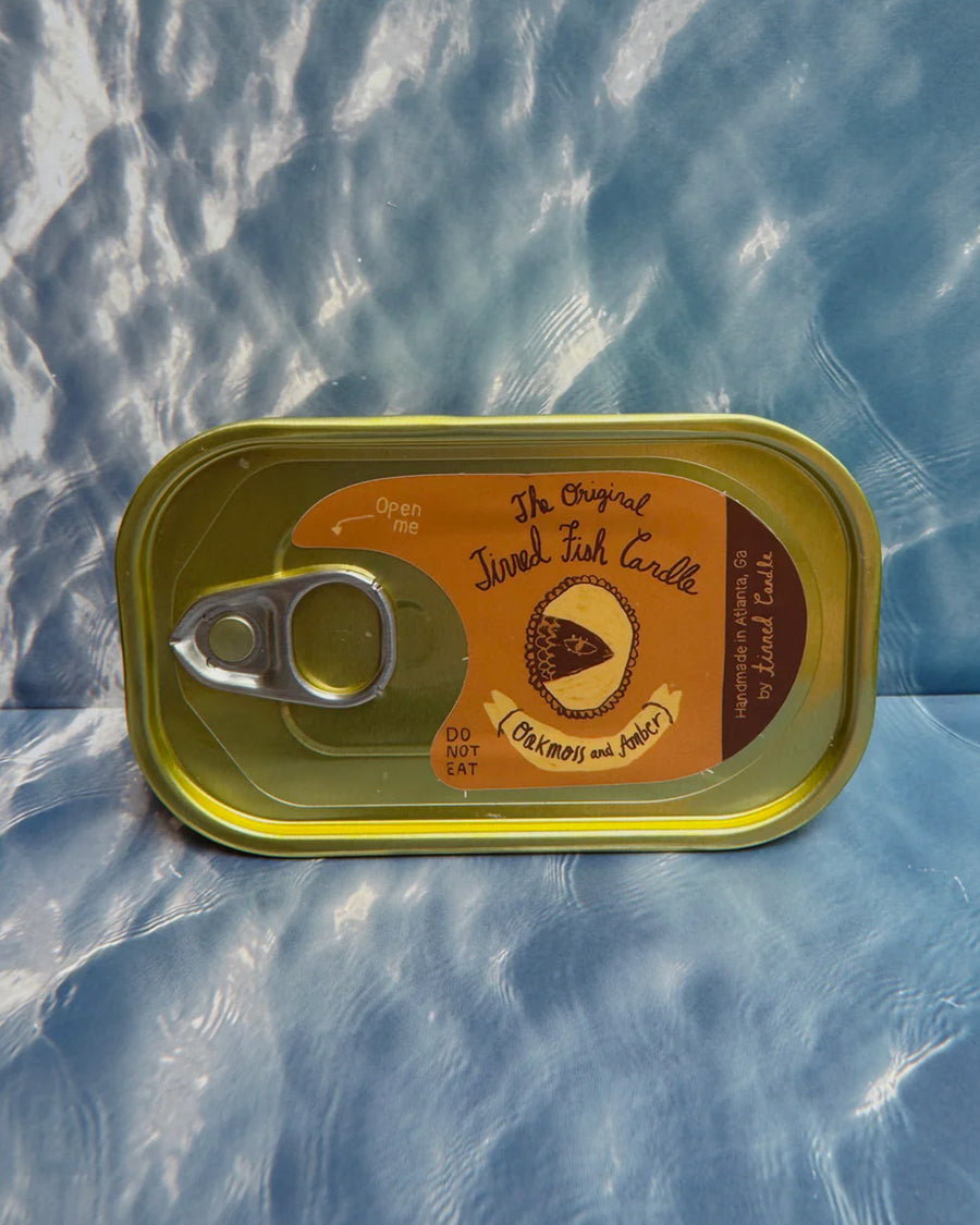 sealed oakmoss and amber scented candle in a fish tin with fish candle inside