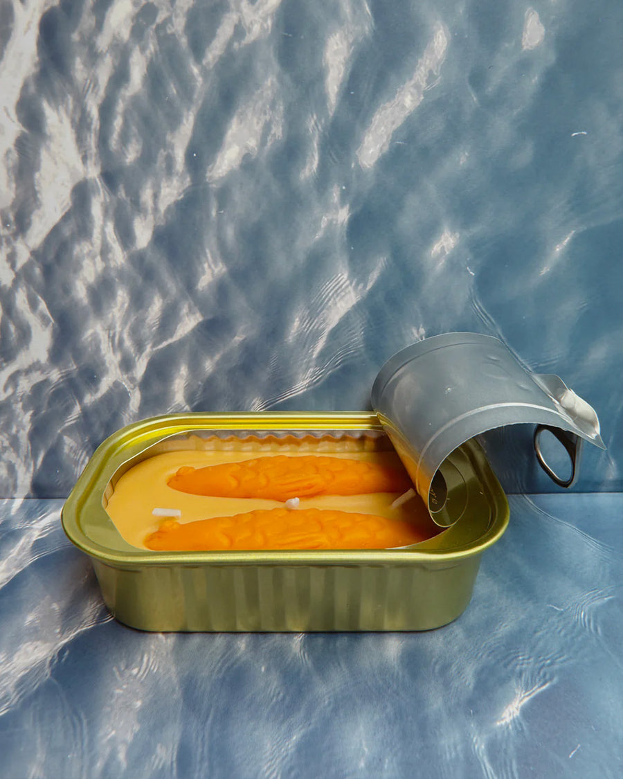 side view of opened sandal scented candle in a fish tin with fish candle inside
