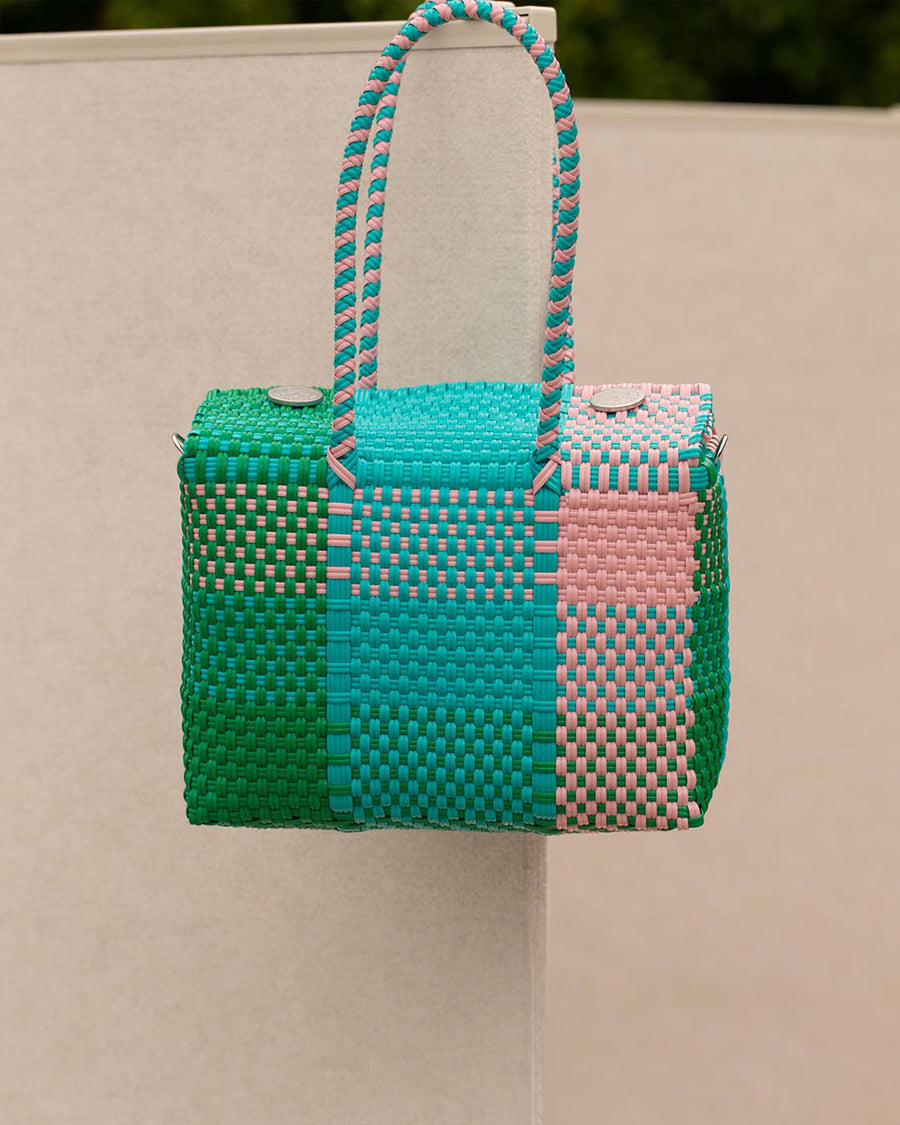front view of teal, pink, and green woven handbag
