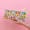 model holding green leatherette pencil pouch with colorful all over floral print