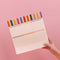model holding tan desk pad with colorful vertical stripe print