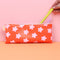 model putting a pen in red leatherette pencil pouch with pink retro flowers
