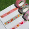 set of three washi tape rolls; red gingham hot dogs, green gingham fruit salad and pink gingham desserts on the grass