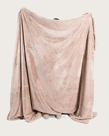 model holding oversized pink fluffy blanket
