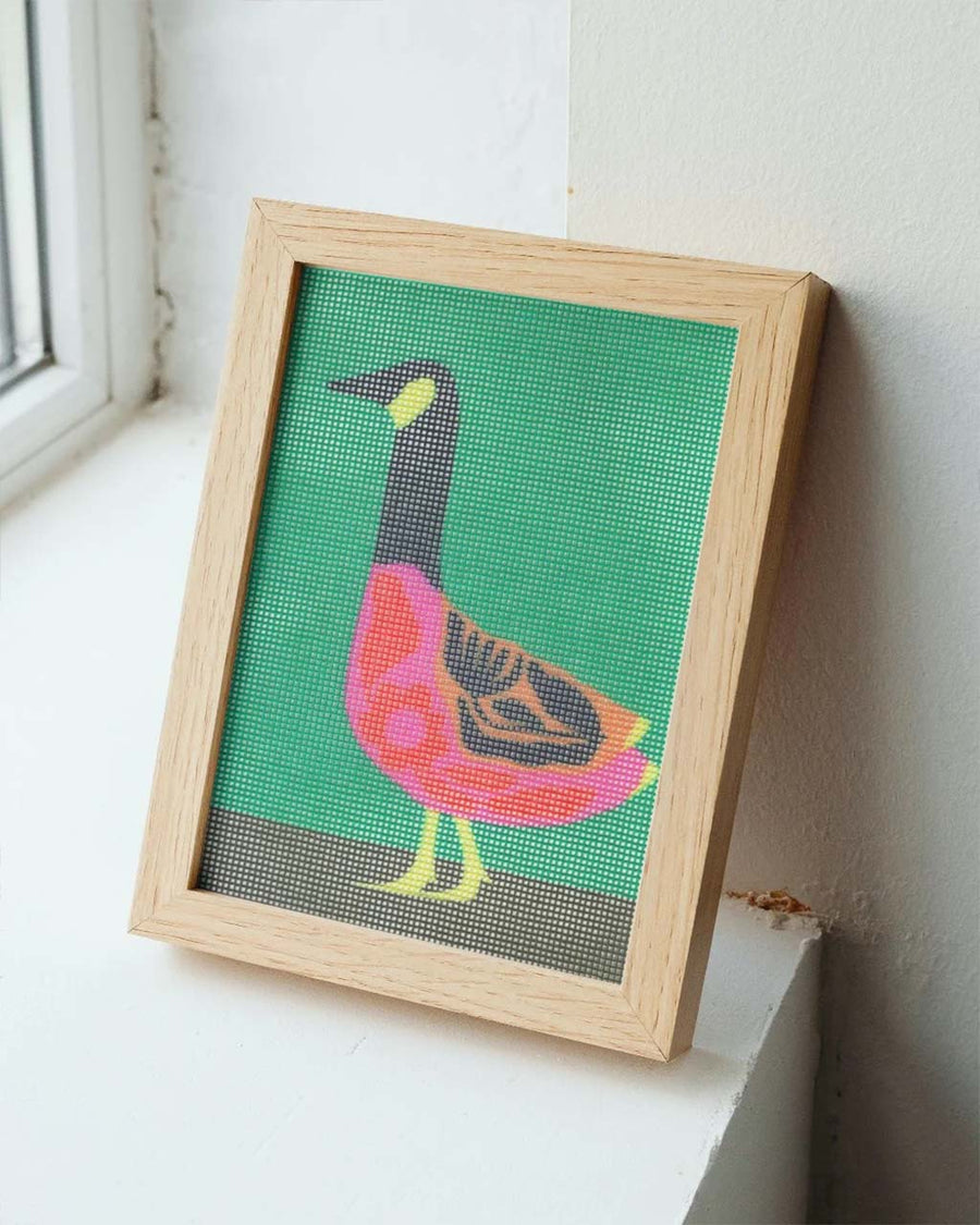 completed folk goose needlepoint in a frame