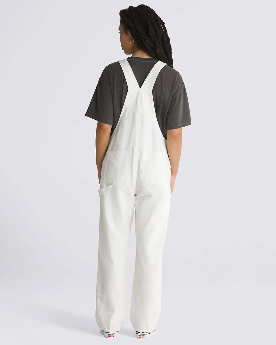 back view of model wearing white overalls with vans patch front