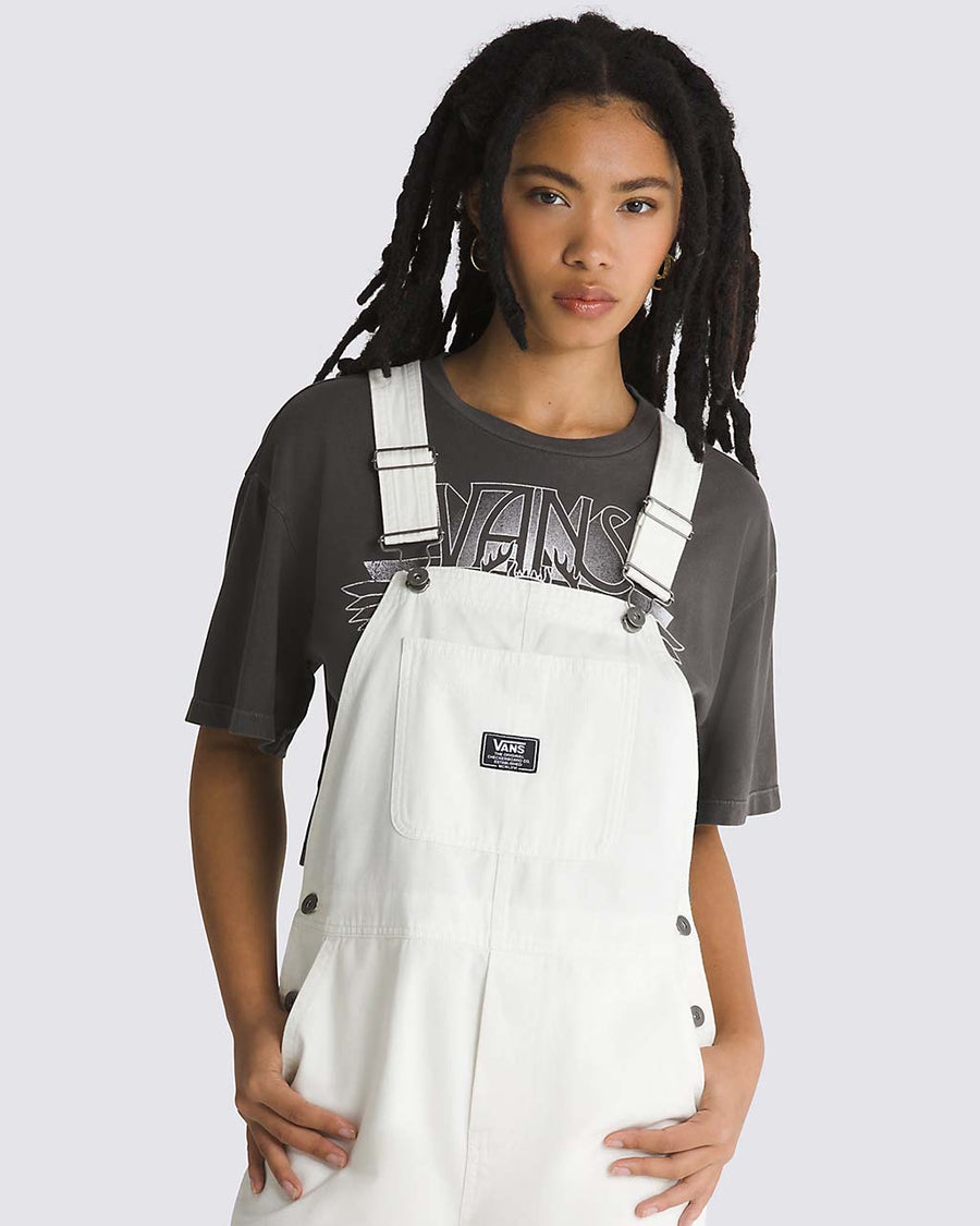 up close of model wearing white overalls with vans patch front