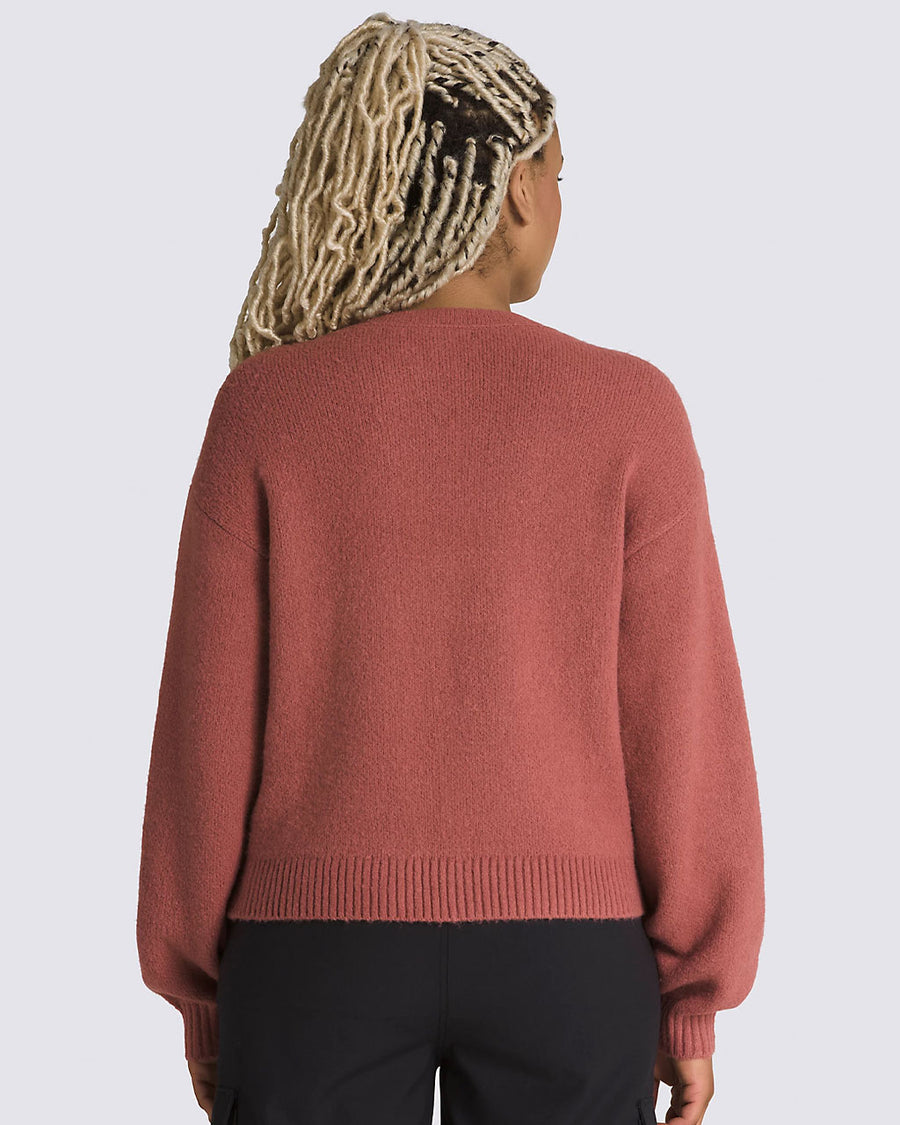 back view of model wearing pink cropped cardigan with button front and vans logo on the left chest