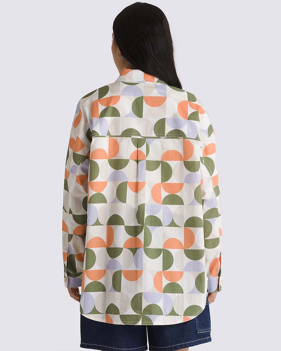 back view of model wearing cream oversized button down shirt with colorful abstract print
