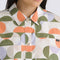 up close of model wearing cream oversized button down shirt with colorful abstract print