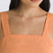 up close of model wearing peach cropped tank with square neckline