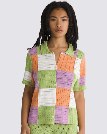 model wearing green, purple, orange, and white checkered button front sweater top