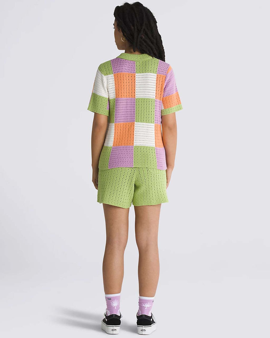 back view of model wearing green, purple, orange, and white checkered button front sweater top