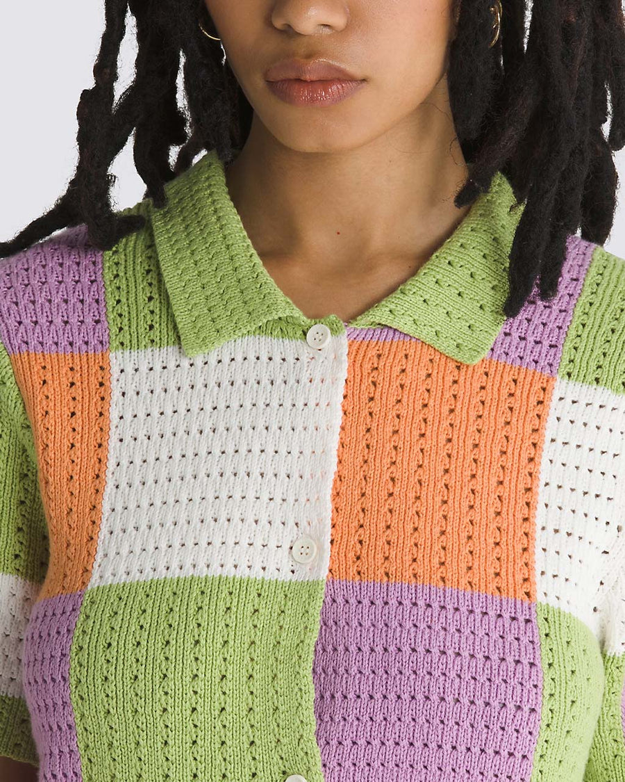 up close of model wearing green, purple, orange, and white checkered button front sweater top