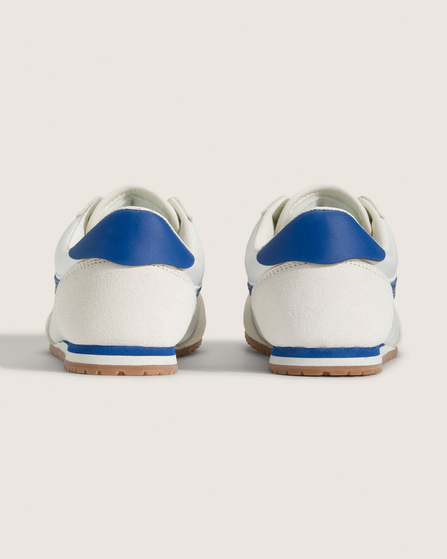 back view of white vans super low pro sneaker with royal blue trim and iconic stripe