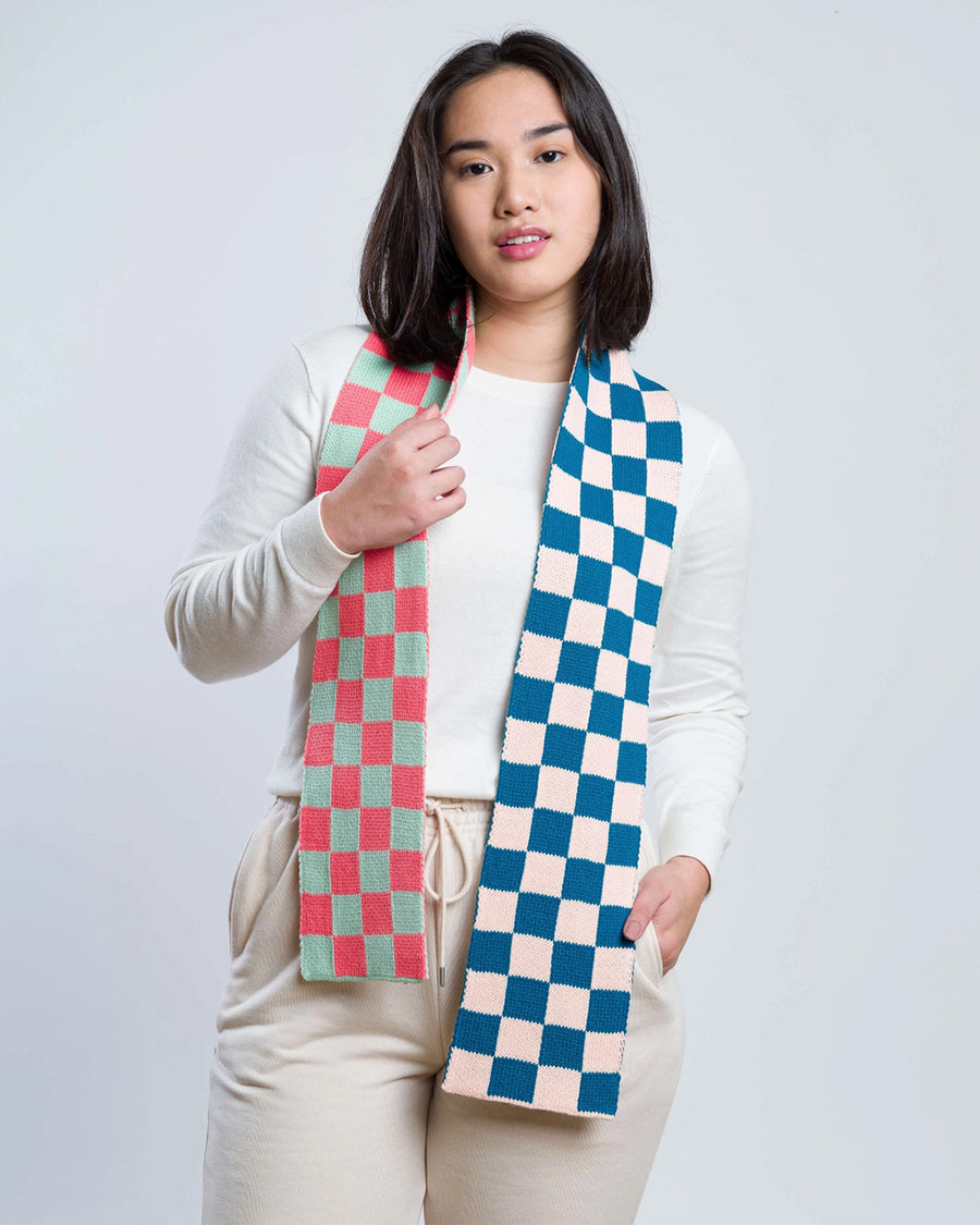 model wearing two toned checkered scarf with navy and light pink checkers and coral and mint checkers