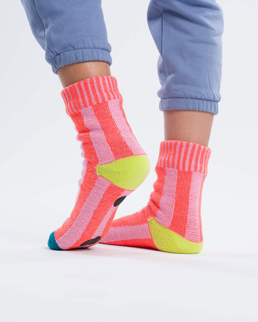 back view of pink striped socks with yellow and blue trim and non-slip bottom