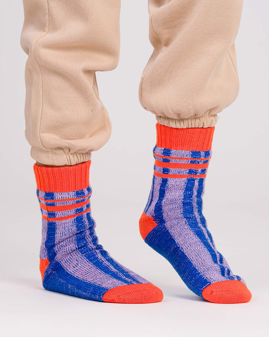 model wearing blue and lilac stripe socks with bright red trim