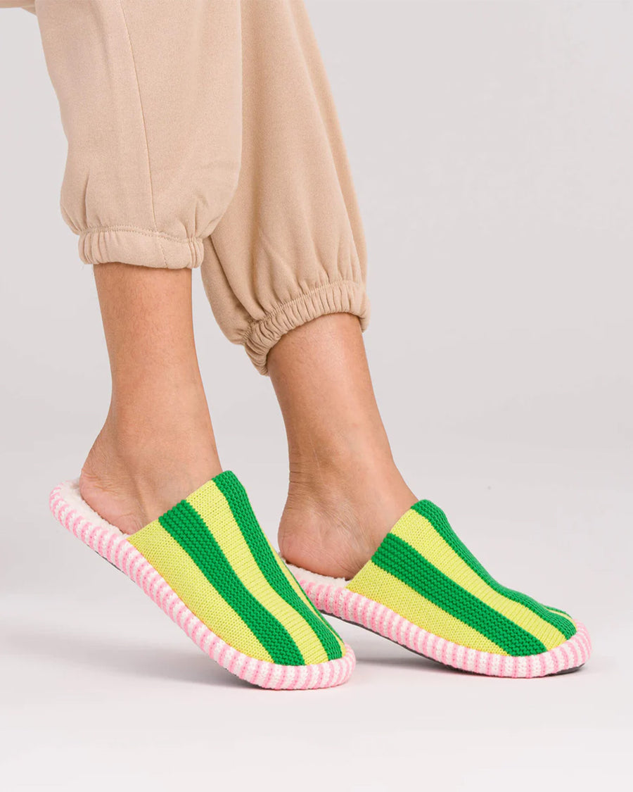model wearing lime green multi striped slide slippers with pink and white sole