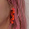 model wearing pink acrylic squiggle earrings