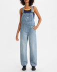 front view of model wearing light blue relaxed fit overalls