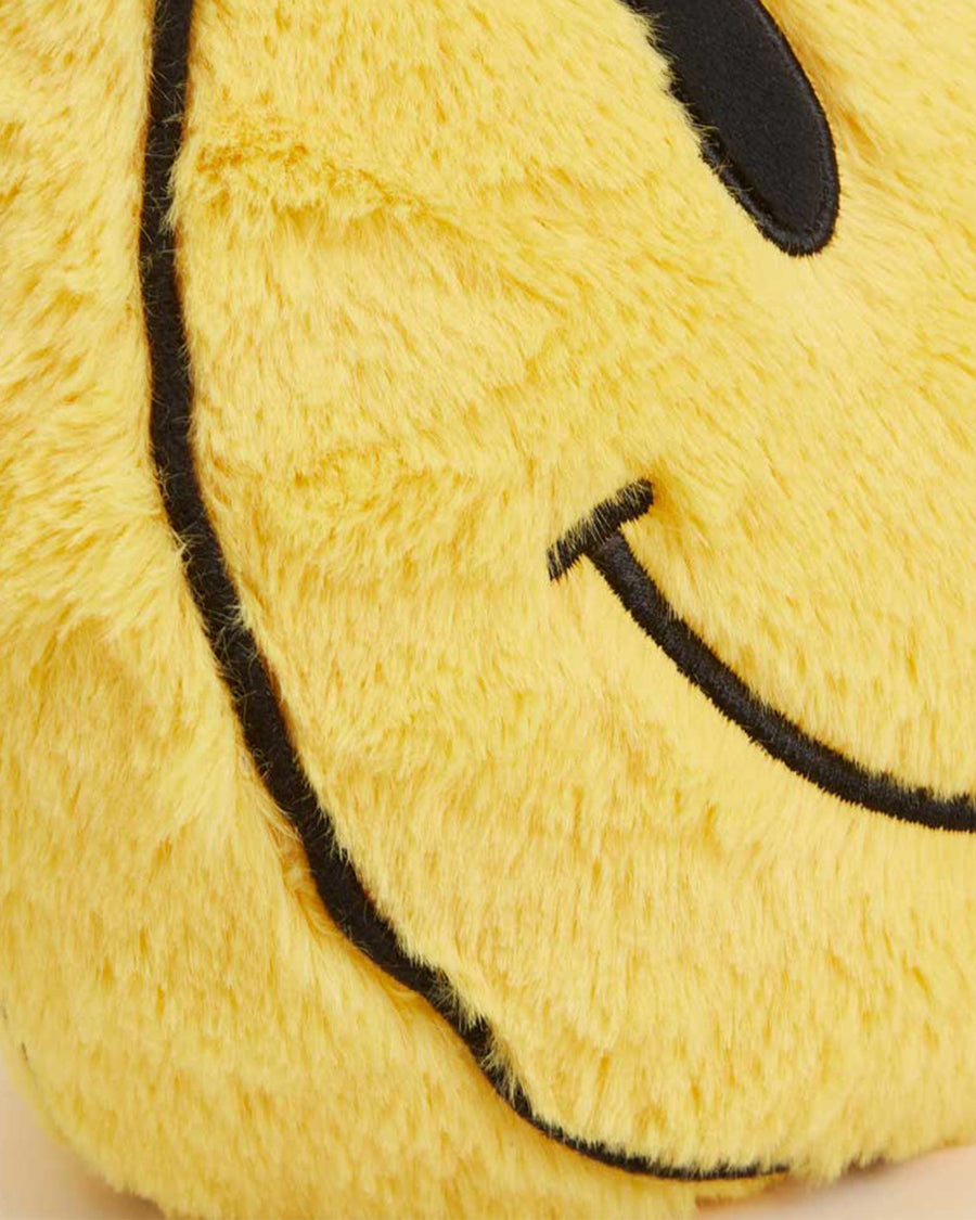 up close of yellow smiley face heating plush